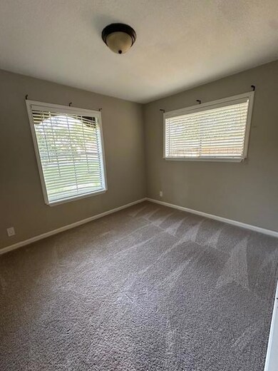 Carpeted empty room with baseboards