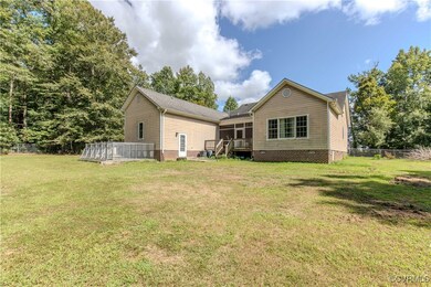 Back of property with a wooden deck and a yard