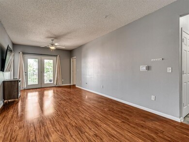 Unfurnished living room featuring ceiling fan, wood finished floors, and a textured ceiling