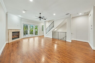 Unfurnished living room with ornamental molding, a fireplace, wood finished floors, recessed lighting, and stairway