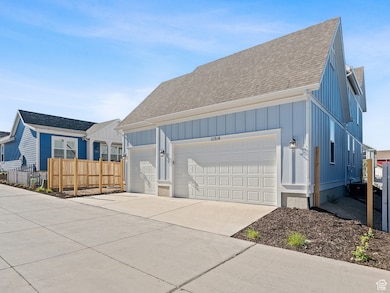 View of property exterior featuring roof with shingles, concrete driveway, board and batten siding, and a garage