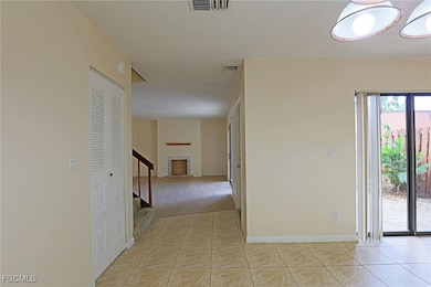 Corridor featuring light tile patterned flooring, a textured ceiling, and stairway