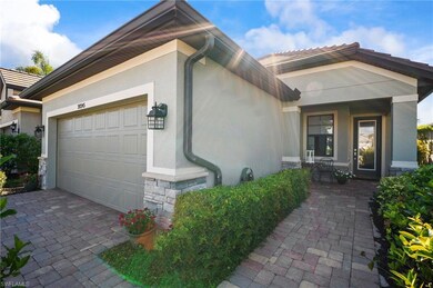 View of front of property featuring a garage, stone siding, stucco siding, and driveway