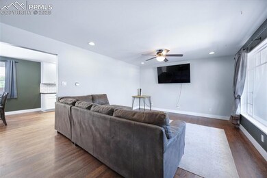 Living area featuring a ceiling fan, baseboards, r