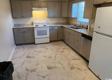 Kitchen featuring white appliances, light marble finish flooring, gray cabinets, and under cabinet range hood