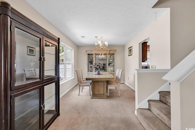 Dining area featuring a chandelier, carpet, basebo