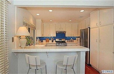 Breakfast bar overlooking bright kitchen with rece