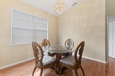 Dining area with a chandelier, light wood-style flooring, and baseboards