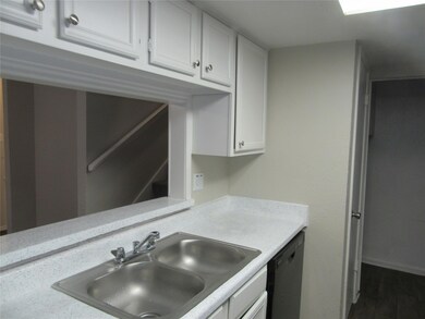 Kitchen featuring white cabinets, dishwasher, dark