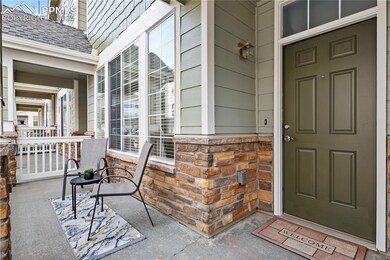 Doorway to property with covered porch and roof with shingles