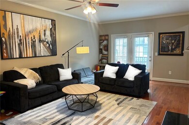 Living area featuring ceiling fan, wood finished floors, and ornamental molding