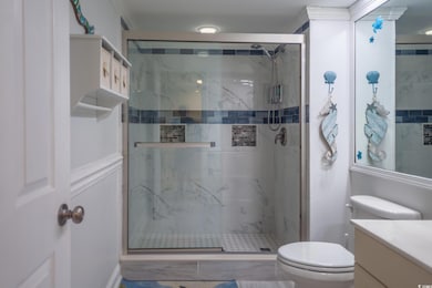 Full bathroom featuring vanity and a marble finish shower