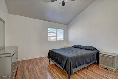 Bedroom with lofted ceiling, wood finished floors,