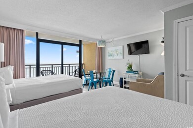 Bedroom featuring access to exterior, a textured ceiling, crown molding, and expansive windows