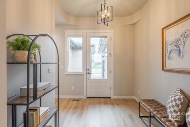 Entrance foyer with wood finished floors and a chandelier