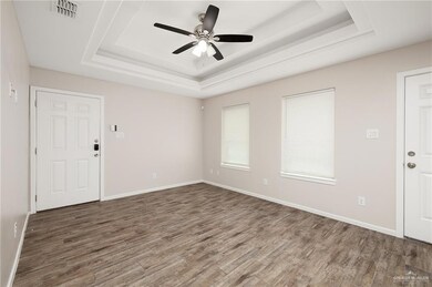 Entrance foyer featuring a tray ceiling, wood finished floors, and a ceiling fan