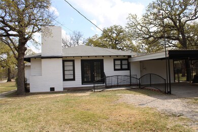 Back of house featuring an attached carport, a chi