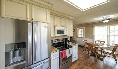Kitchen with a textured ceiling, a wainscoted wall