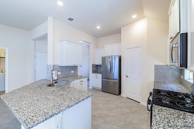 Kitchen with visible vents, a sink, appliances wi