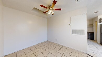 Tiled spare room featuring ceiling fan