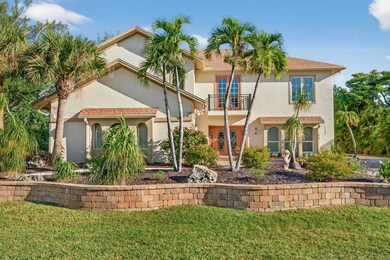 Front of house with a balcony, a yard, and stucco siding