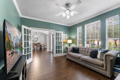 This dedicated office space features French doors, elegant crown molding, and plenty of natural light from multiple windows.