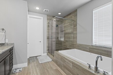 Bathroom featuring a garden tub, visible vents, a 
