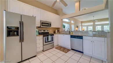 Kitchen with a sink, white cabinetry, ceiling fan,