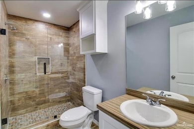 Full bath with vanity, a shower stall, and toilet