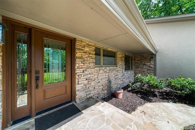 Property entrance with stone siding, stucco siding