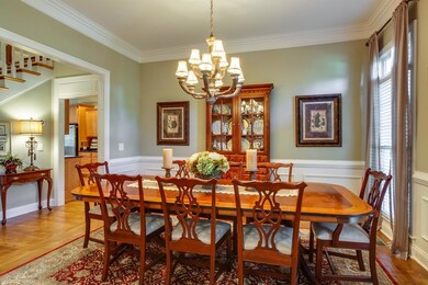 Wainscoting and crown molding are featured in the formal dining room which could accommodate a piano as a music room. 