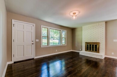 The pristine hardwoods and painted brick fireplace complete this cozy living room.  GOOD TO KNOW: fireplace never used by sellers and sold as-is