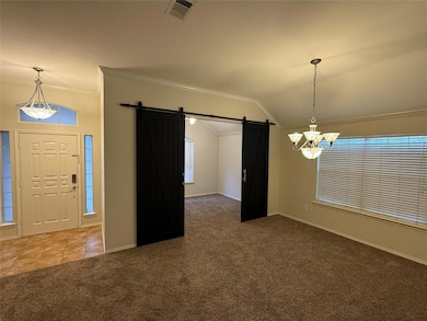 Foyer entrance with a barn door, crown molding, ca