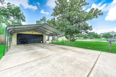 Spacious driveway with a large metal carport leadi