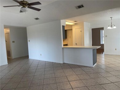 Den with view of kitchen and hallway to the left.