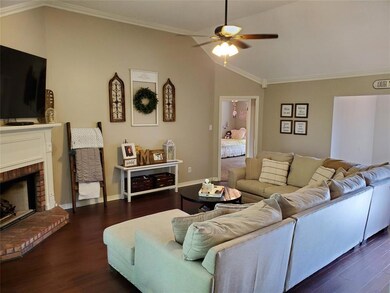 Living room with fireplace and vaulted ceiling.