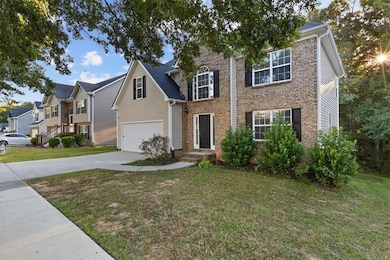 Traditional home featuring a front yard, driveway, and brick siding