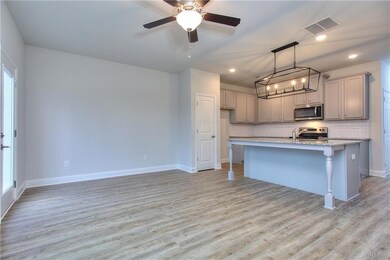 Kitchen with light stone countertops, light hardwo