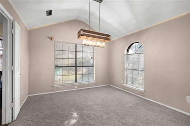Unfurnished dining area featuring lofted ceiling, crown molding, and carpet floors