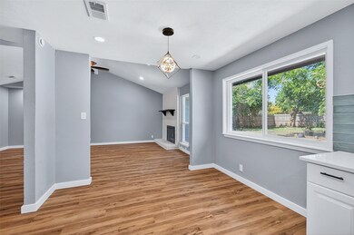 Unfurnished dining area featuring light wood-style flooring, recessed lighting, lofted ceiling, and a brick fireplace