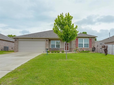 Ranch-style home featuring brick siding, an attached garage, and concrete driveway