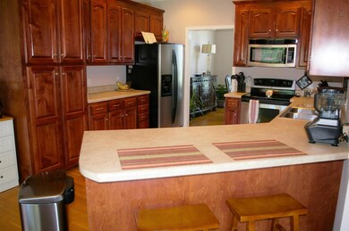 Kitchen has stainless steel appliances and bar