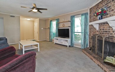 Carpeted living room featuring crown molding, a br