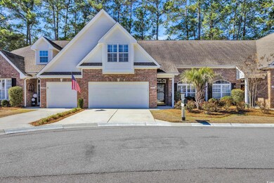 View of property with brick siding, driveway, and 