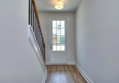 Entryway featuring wood-style finished floors, bas