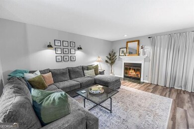 Living area featuring wood finished floors and a glass covered fireplace