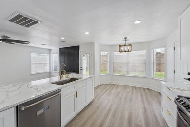 The cozy breakfast nook is surrounded by large win