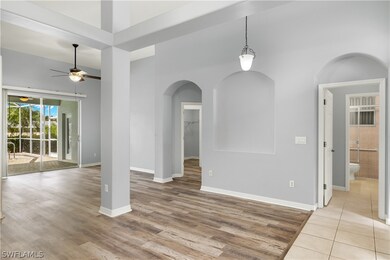 Tiled empty room featuring ceiling fan and a high ceiling