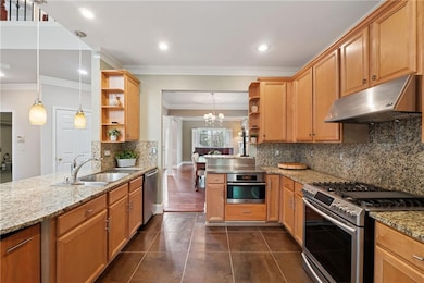 Kitchen with a peninsula, open shelves, under cabinet range hood, stainless steel appliances, and a sink