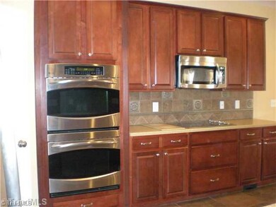 Kitchen. Pantry~ Stainless Steel Double Ovens and Microwave~ Beautiful Cherry cabinetry~ Custom Backsplash and Solid Surface Counters~ notice the vacuum system makes cleaning a breeze!